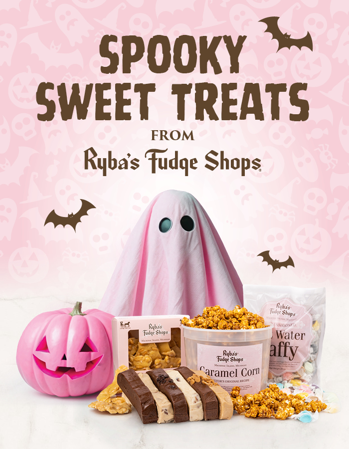 A cute pink ghost and pumpkin next to Halloween treats.